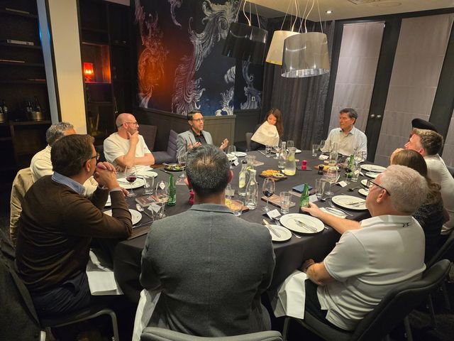 Rahim Hirji speaking at a dinner table of senior leaders