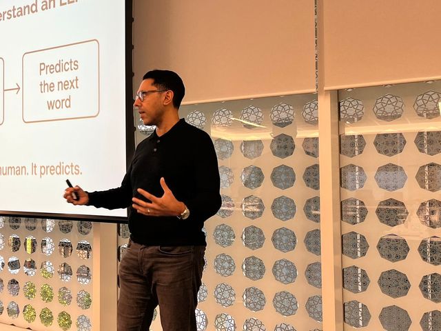 Rahim Hirji facilitating a small board session beside a screen